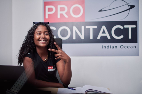 ProContact centre de contact en action Jeune femme souriante avec téléphone dans un centre de contact.