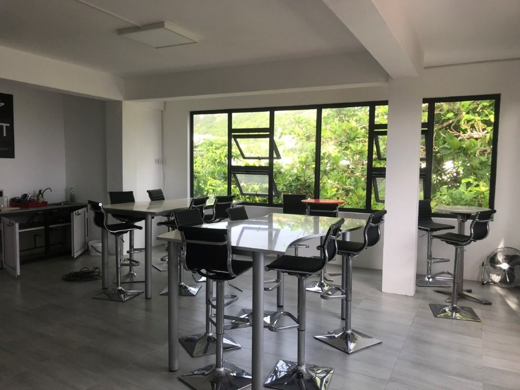 Salle de réunion moderne avec grandes fenêtres et mobilier noir.