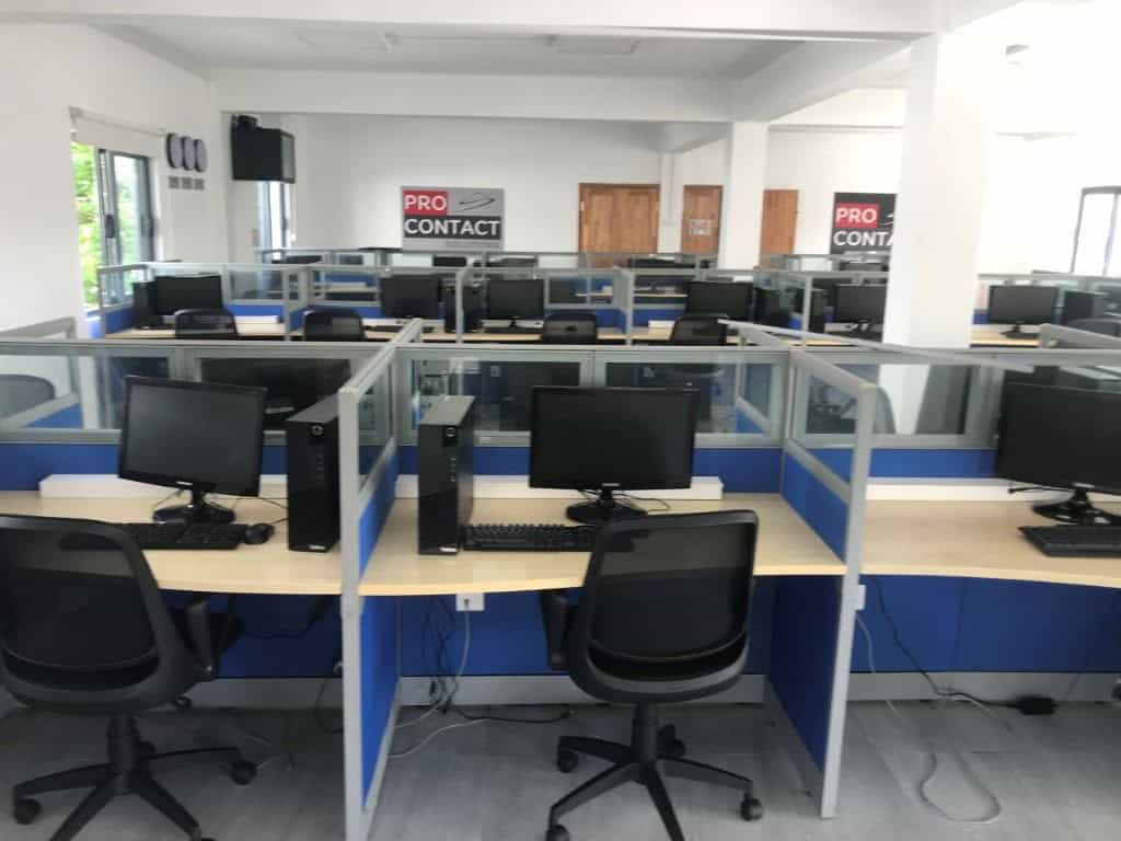 Bureaux modernes avec ordinateurs et chaises dans un centre de contact.