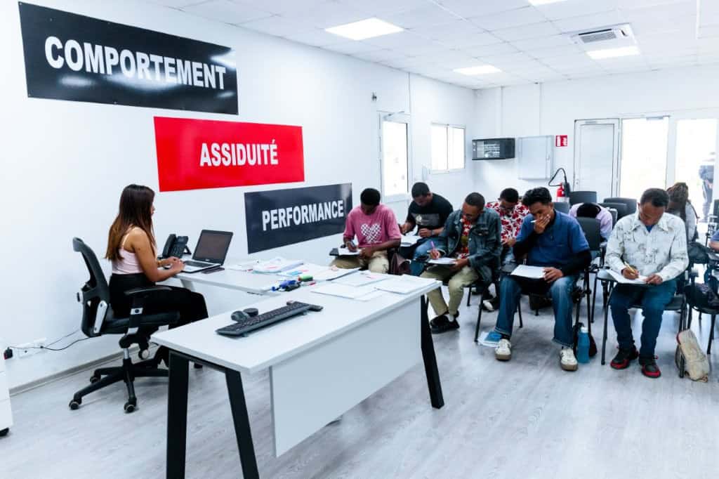 Formation en centre d'appels avec plusieurs agents et un formateur.