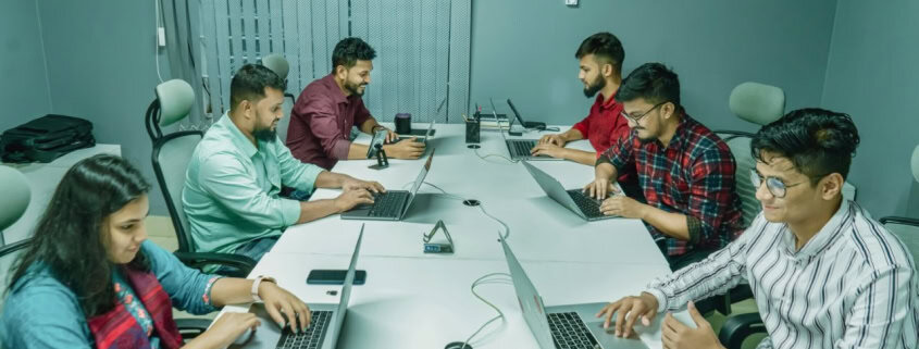 Groupe de collègues en réunion dans une salle de conférence moderne.