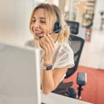 Assistante au centre de contact avec casque et sourire.
