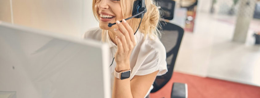 Assistante au centre de contact avec casque et sourire.