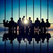 SLA back-office : suivi des délais et de la qualité Réunion d'affaires avec silhouettes de personnes dans une salle de conférence.SLA back-office avec suivi des délais et contrôle qualité
